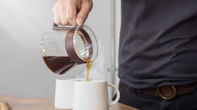 coffee pot pouring into two mugs