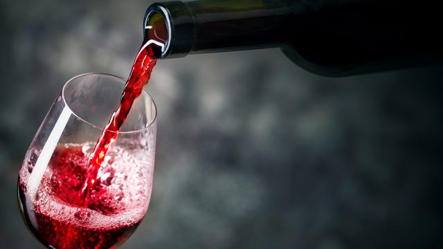 red wine being poured from bottle into glass