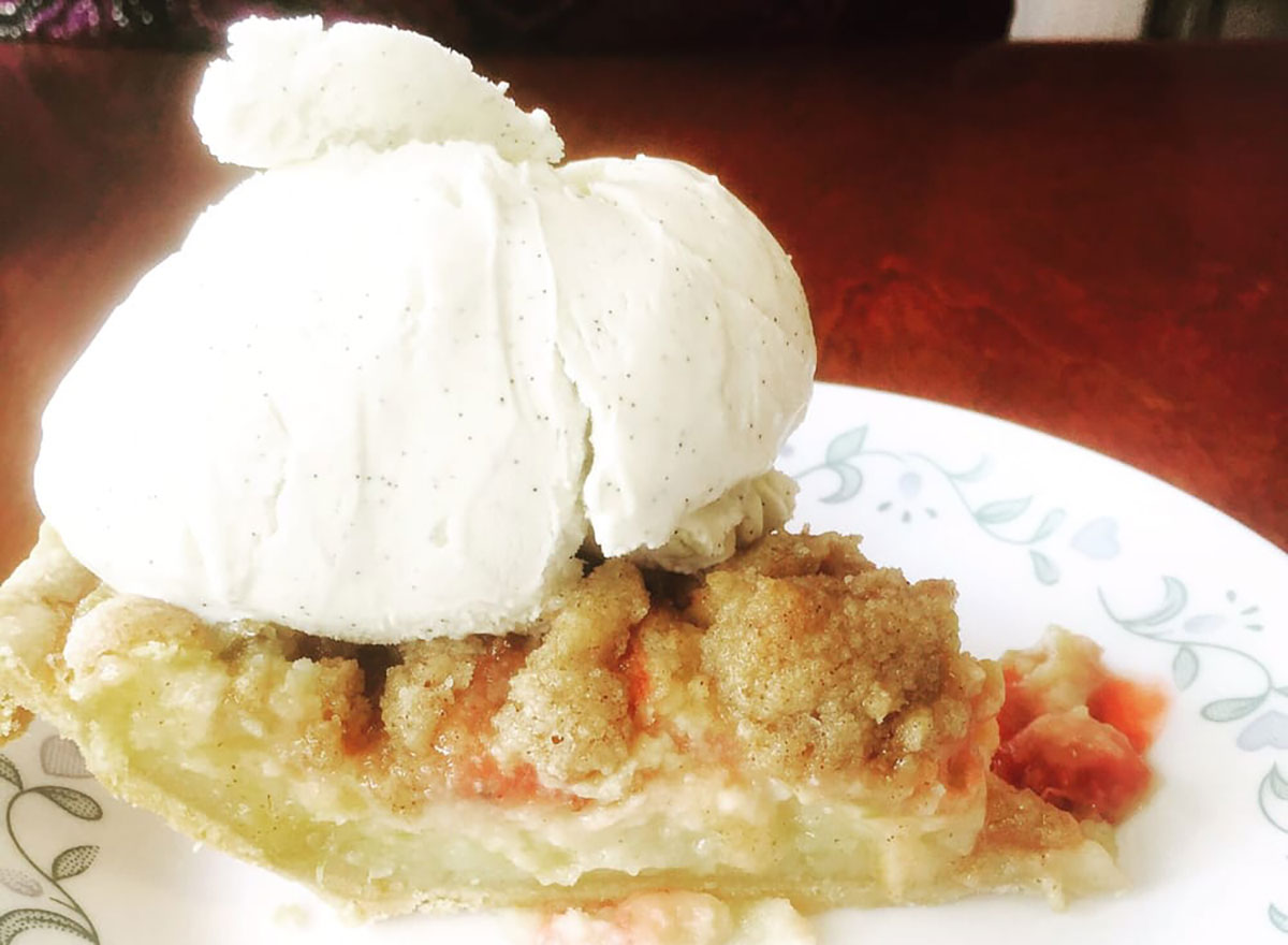 slice of sour cream strawberry rhubarb pie with ice cream