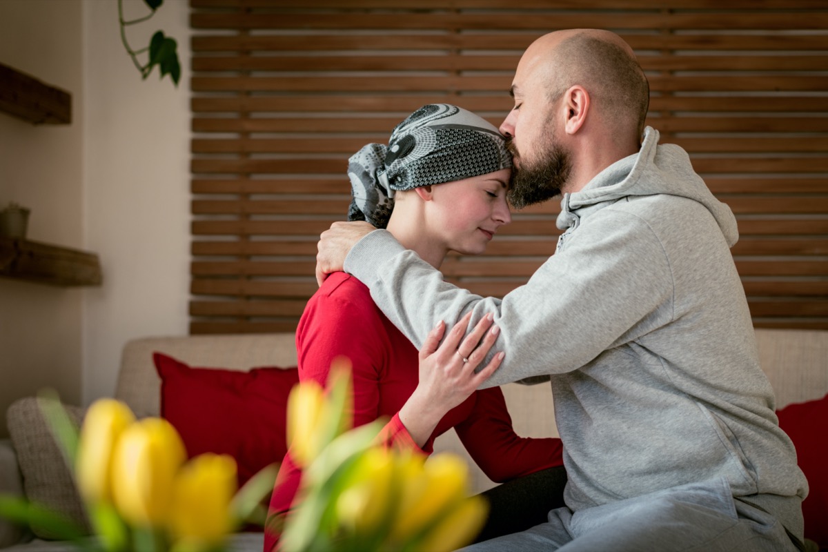 Supportive husband kissing his wife, cancer patient, after treatment in hospital