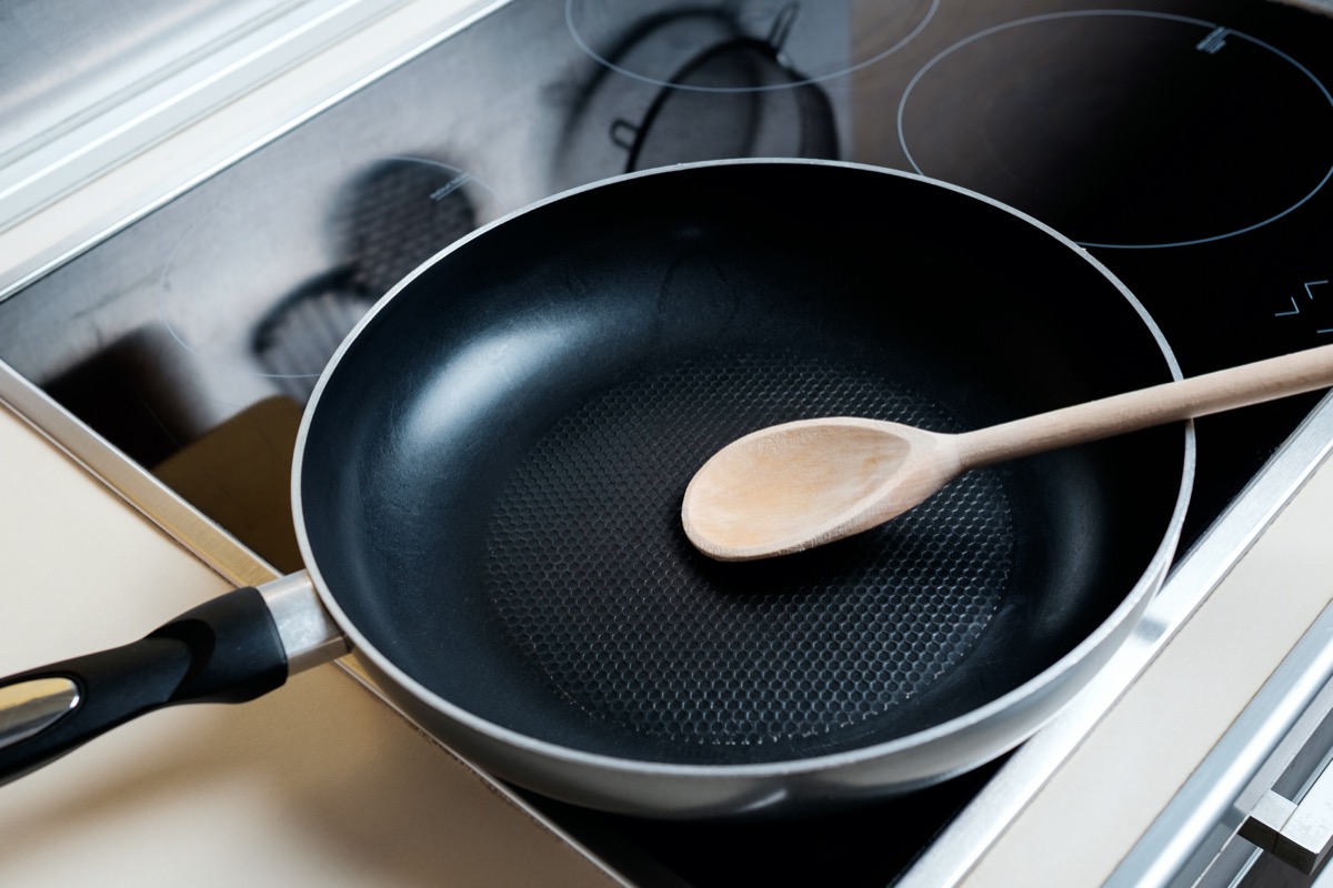 Dripping pan, wood spoon and black induction cooker. 