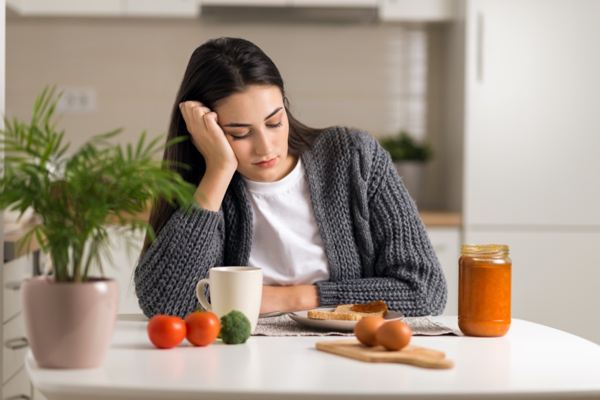 The unhappy young woman does not want to eat breakfast