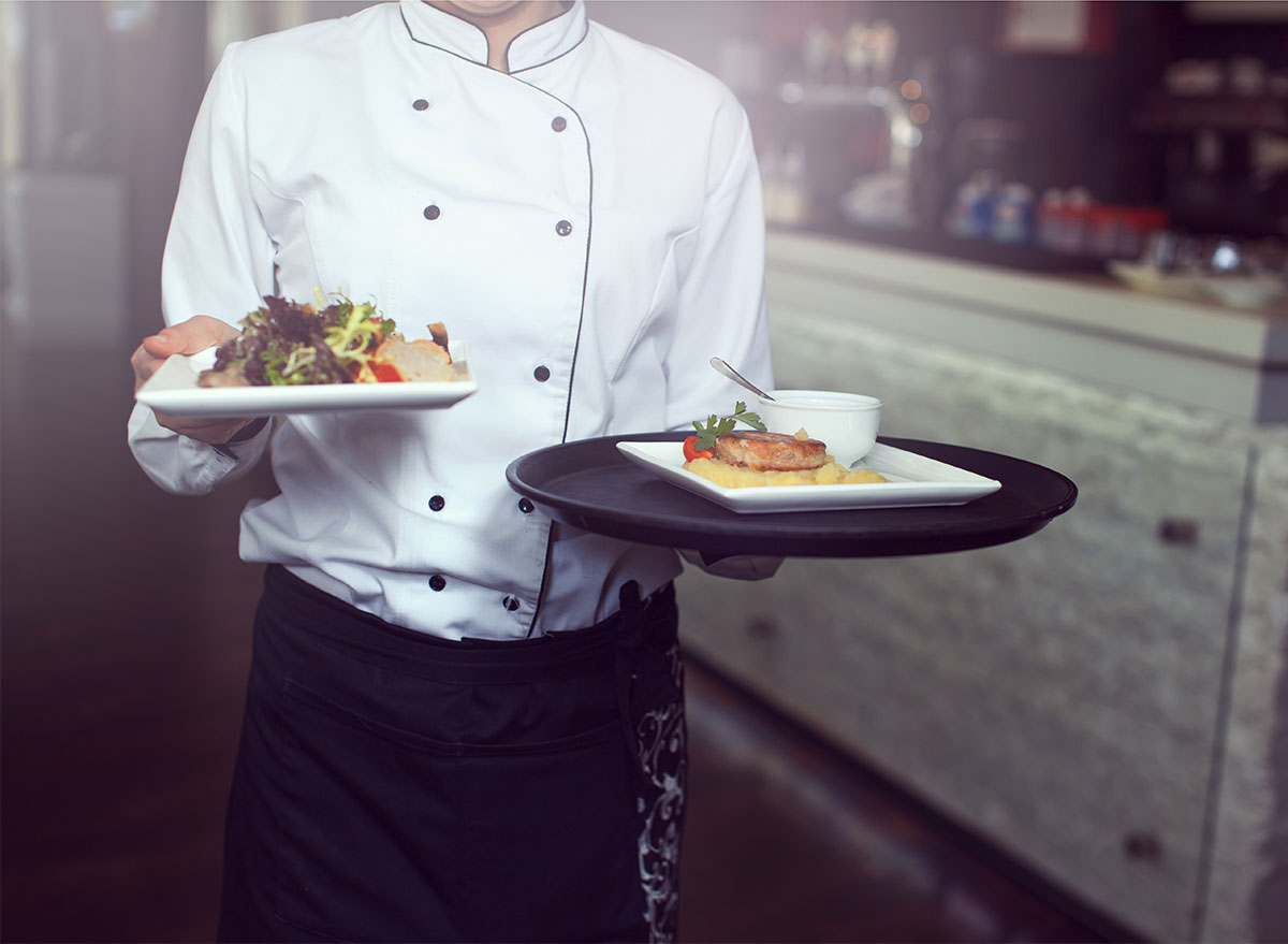 waiter carrying plates of food