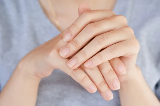 Woman looking at fingernails