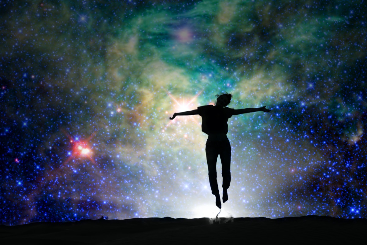 Silhouette of a woman jumping, starry night background