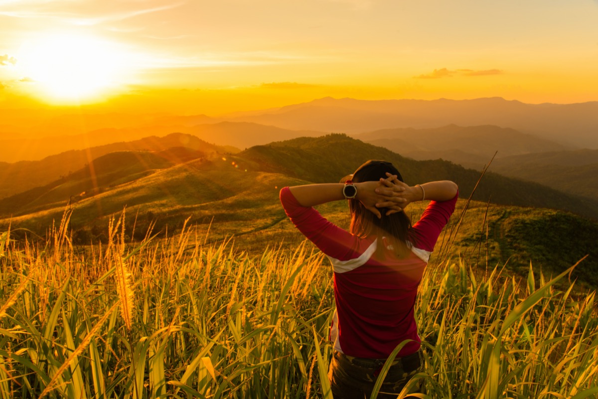 A tourist girl looking mountain landscape at the sunset time