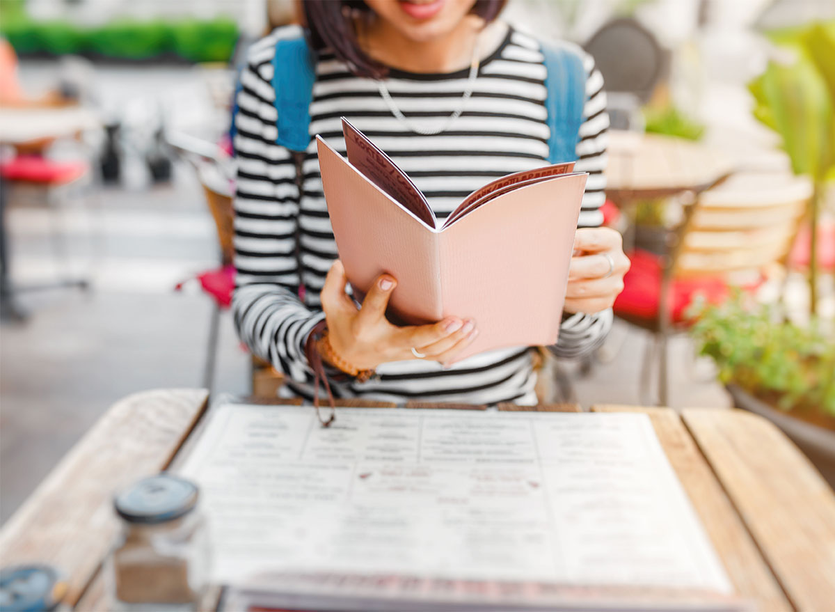 woman reading menu outdoor cafe
