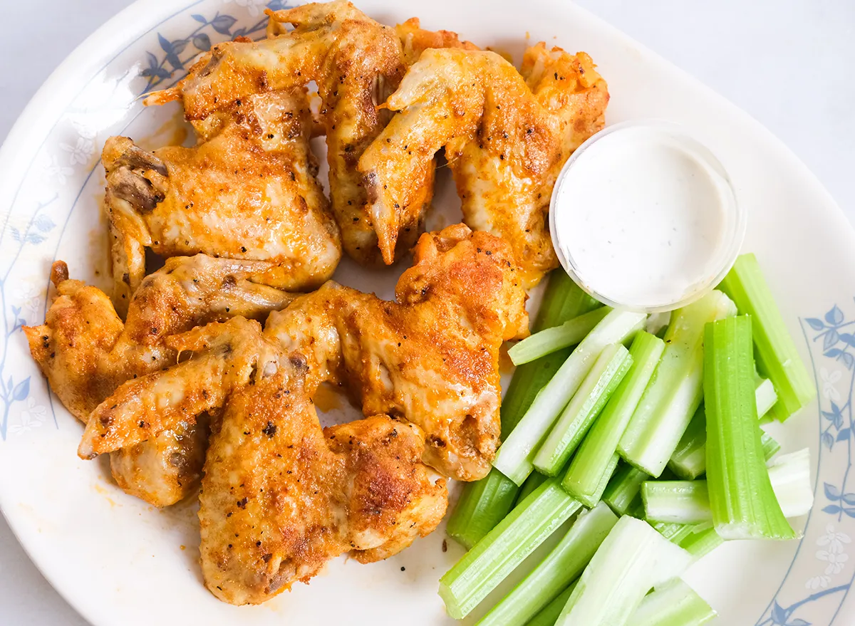 finished chicken wings with blue cheese dip and celery on a plate