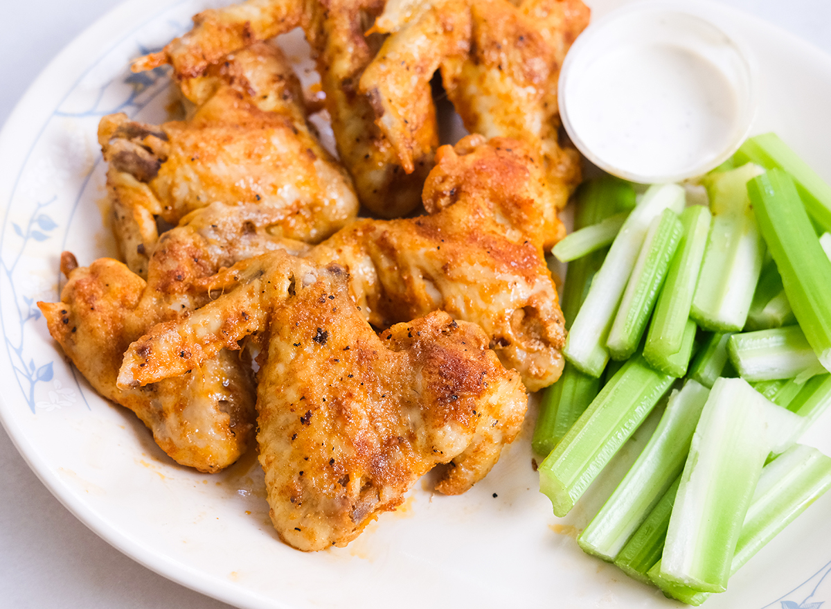 chicken wings on a plate with celery and dip