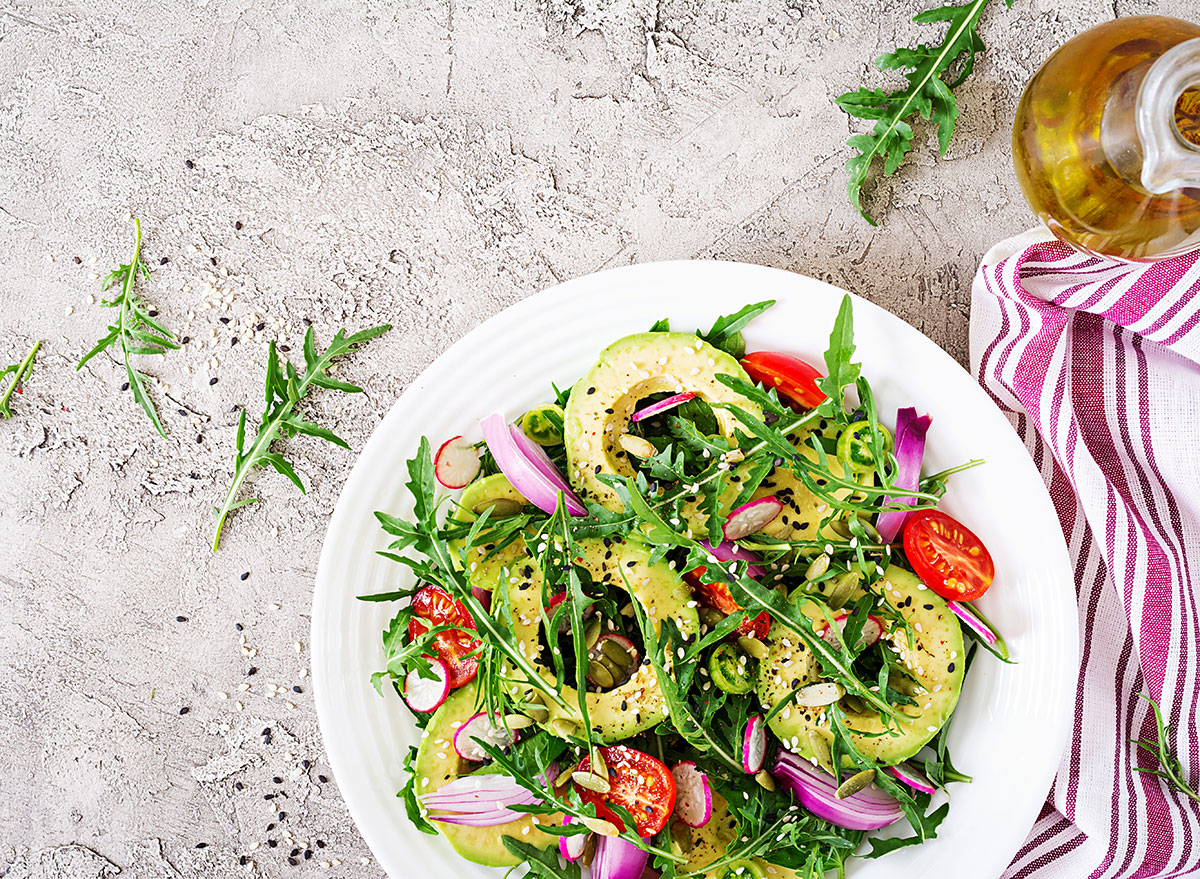 Salat med tomater, avokado, arugula, reddik, frø på en bolle