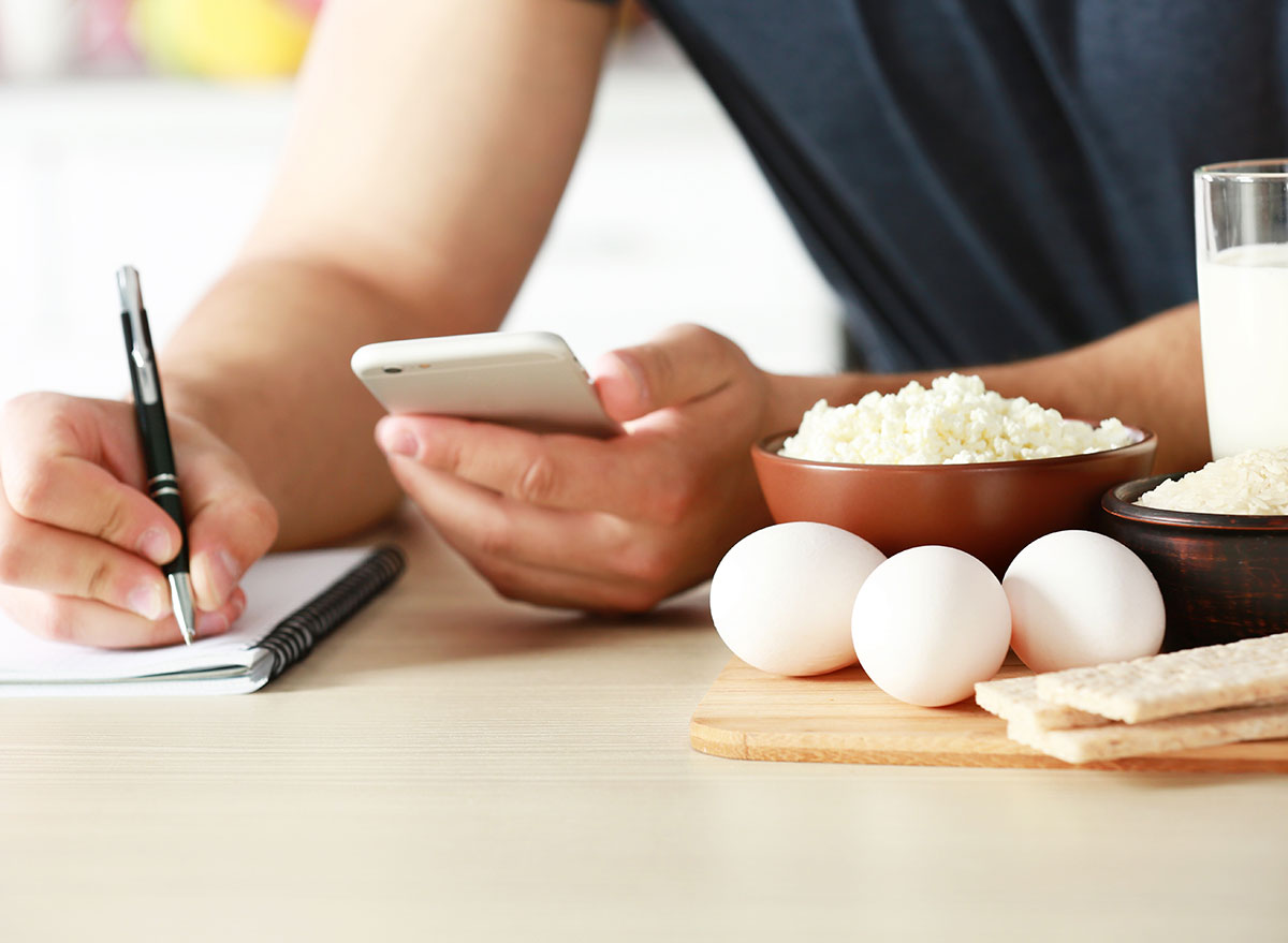 person counting calories and keeping track in notepad