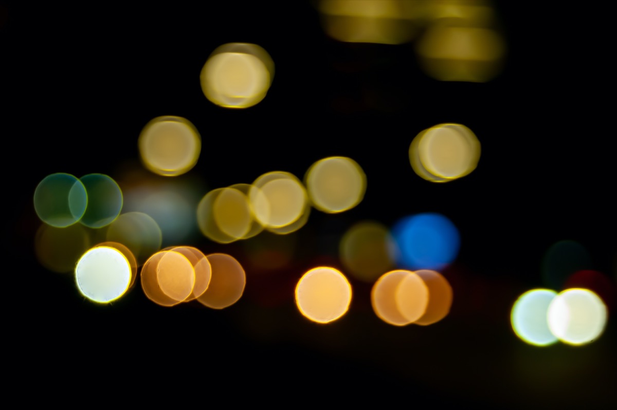 light of street lamps and headlights of driving cars at night in the city