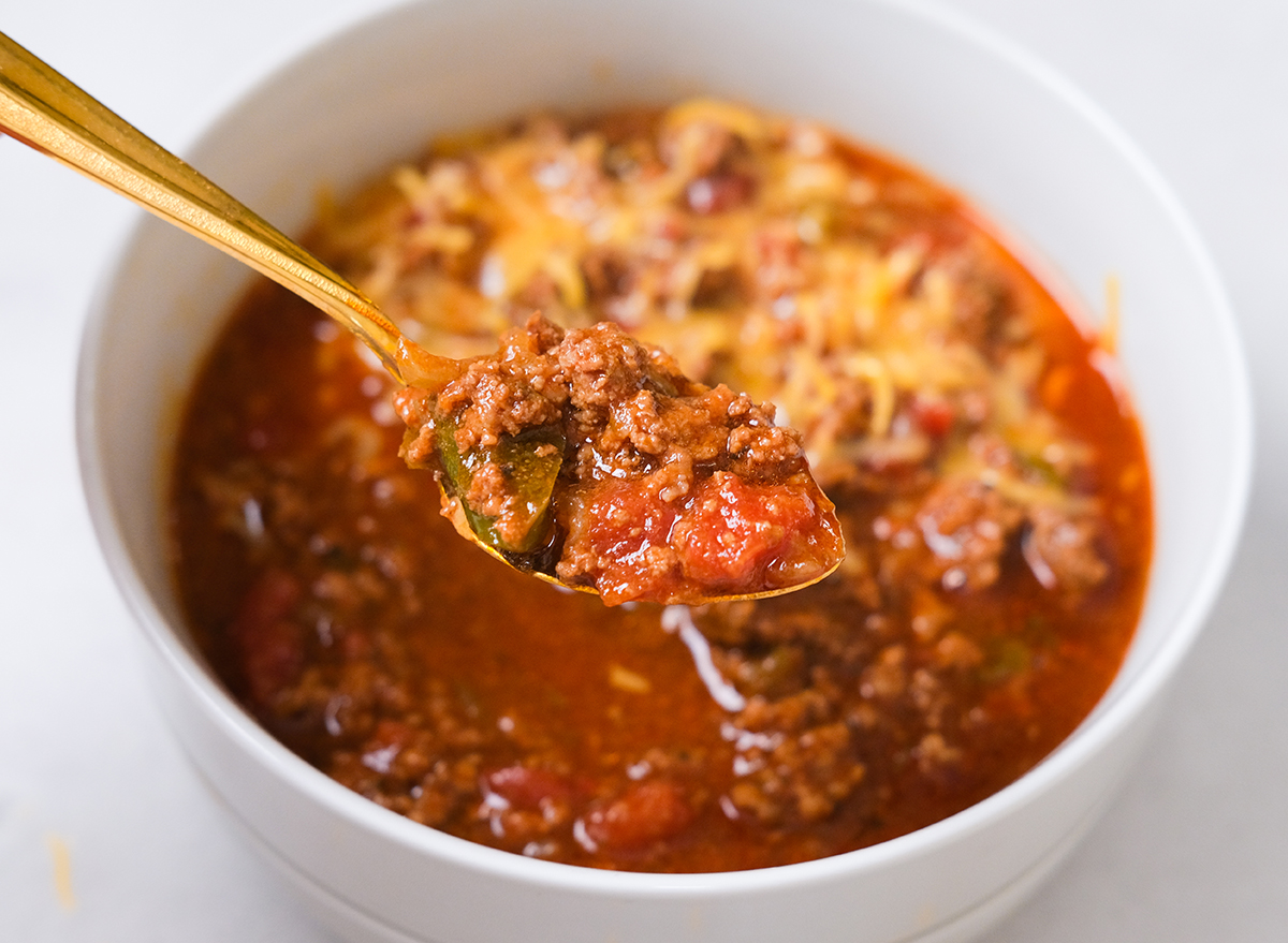 spoon holding up chili from a bowl