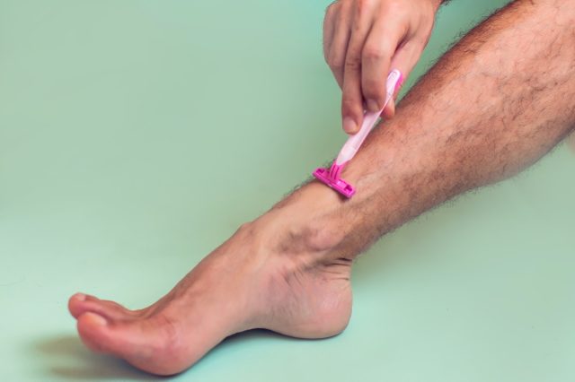 Man shaves his leg isolated