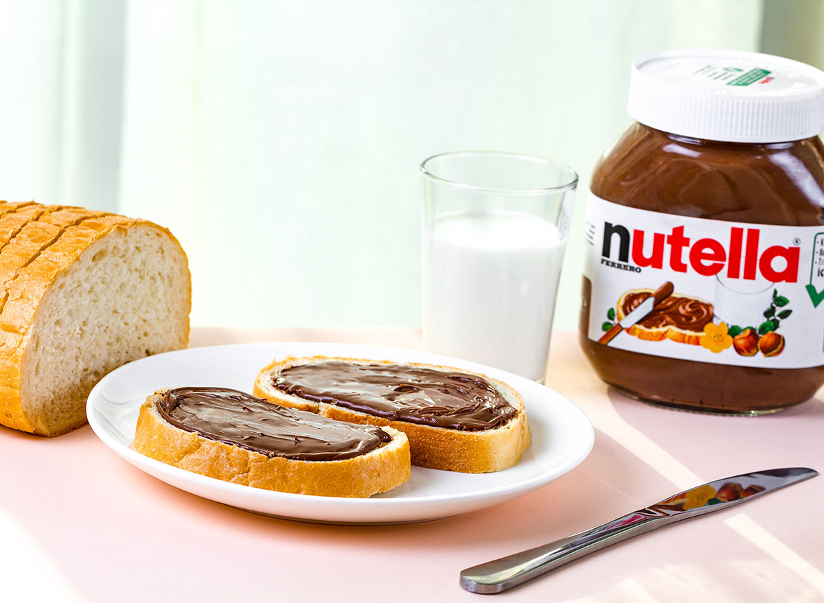 nutella on bread with glass of milk and knife