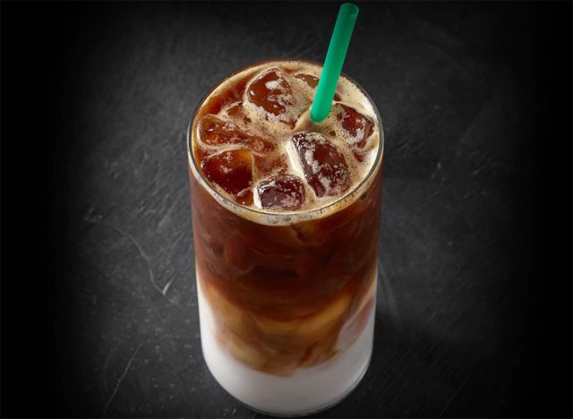 starbucks blonde vanilla latte in a glass on a plain background.