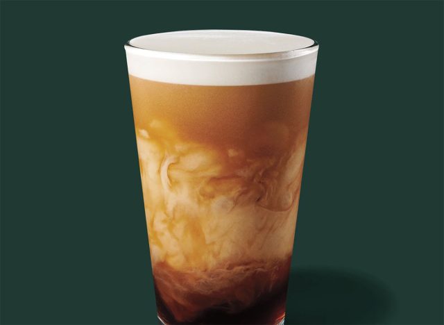 starbucks nitro sweet cream cold brew in a glass on a green background.