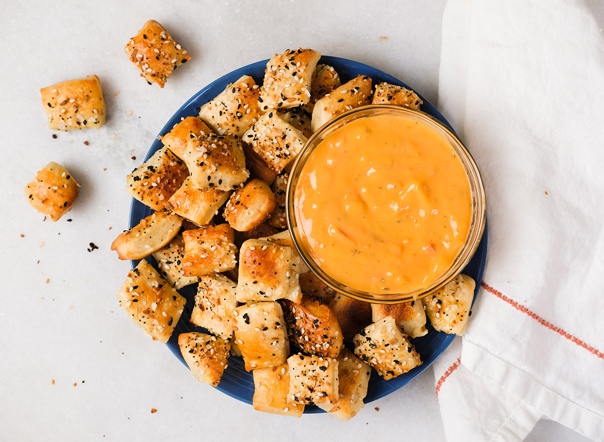 pretzel bites and everything seasoning with queso on a plate