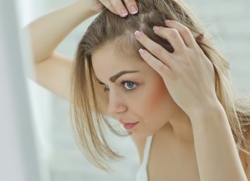 nervous girl looking in the mirror her scalp