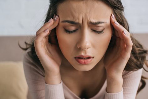 woman with closed eyes suffering from headache