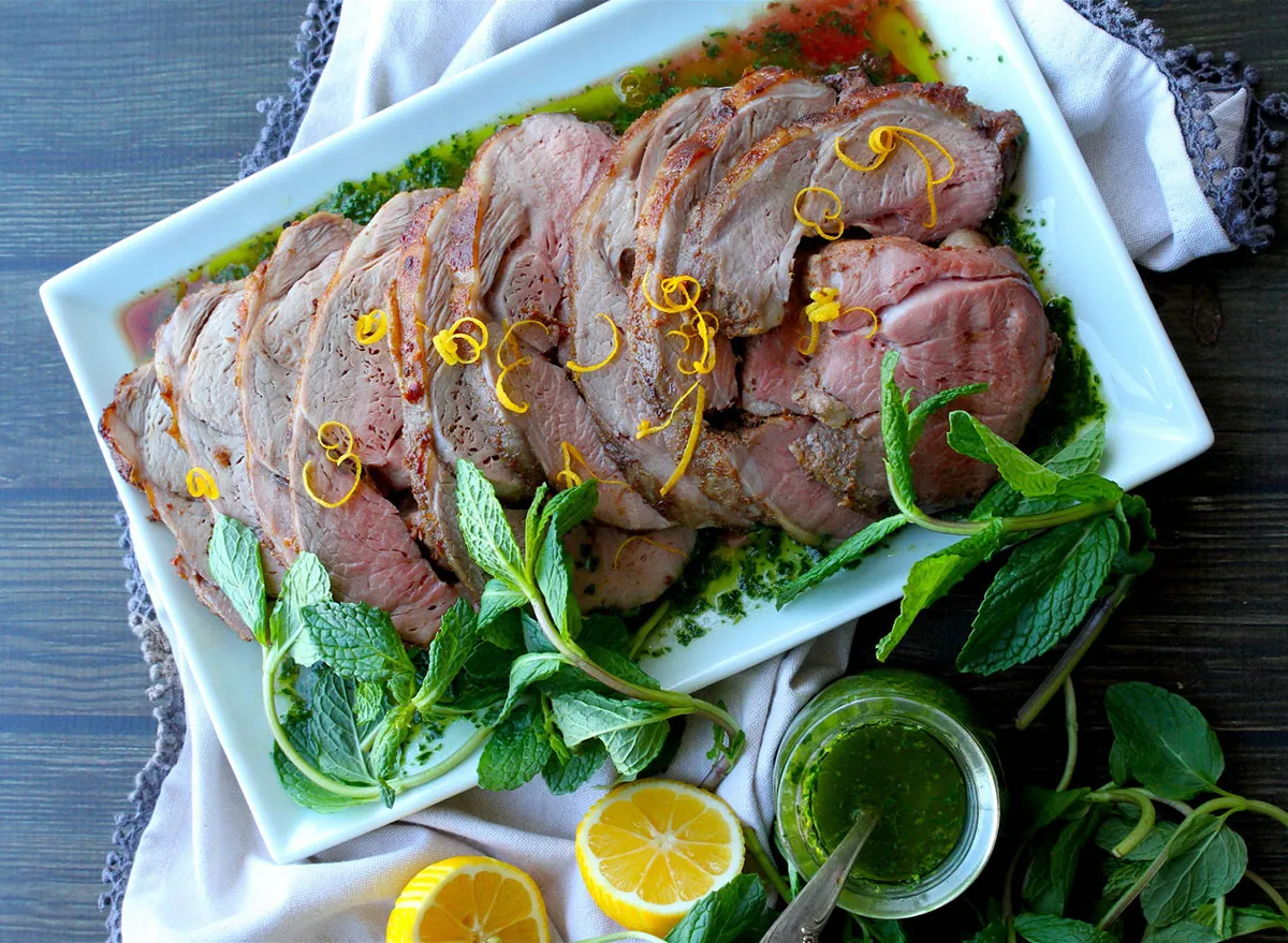 boneless leg of lamb with chimichurri on white serving plate