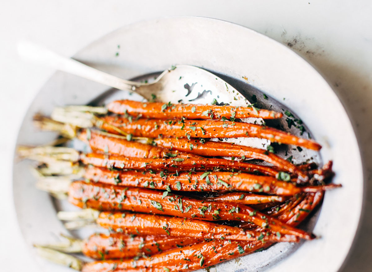 brown butter honey glazed whole carrots in white serving dish