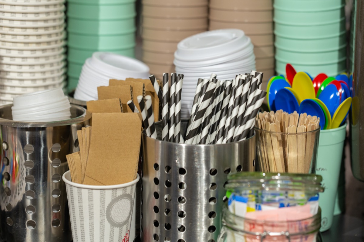 Striped drinking straws, coffee cups, lids, wooden sticks, plastic spoons