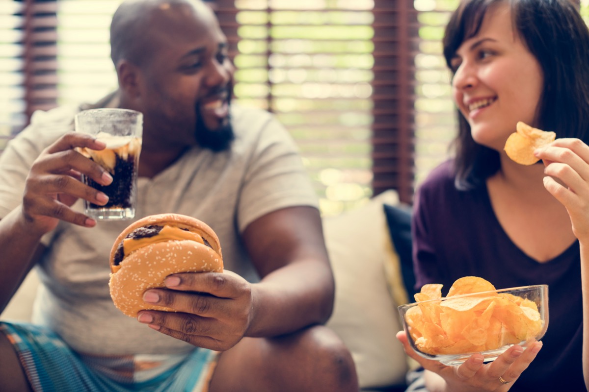 Couple having fast food on the couch