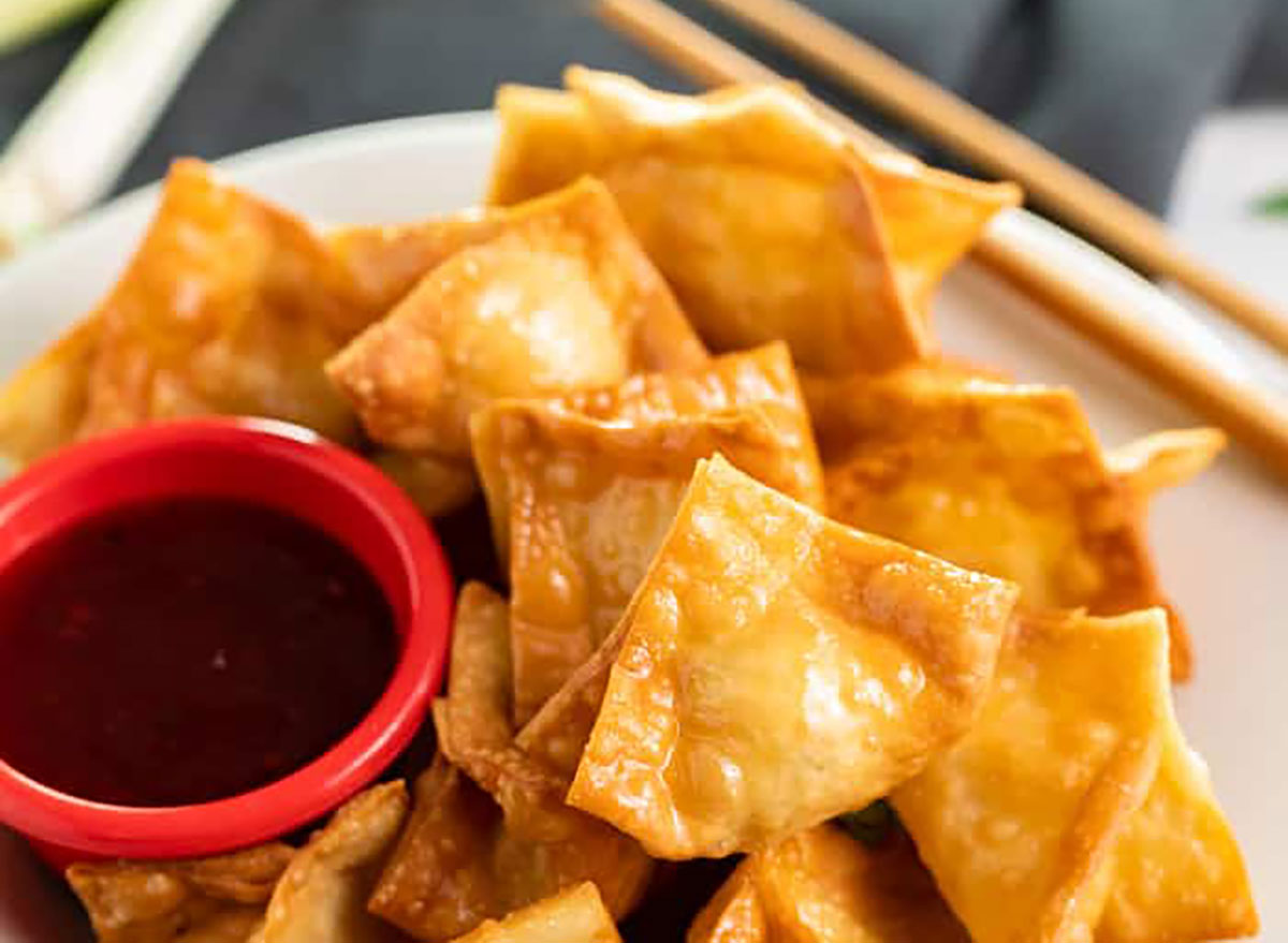 homemade crab rangoons with dipping sauce on serving platter