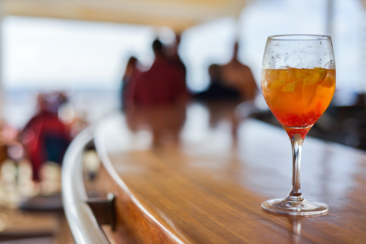 Horizontal, close up shot of a glass of white sangria on a bar