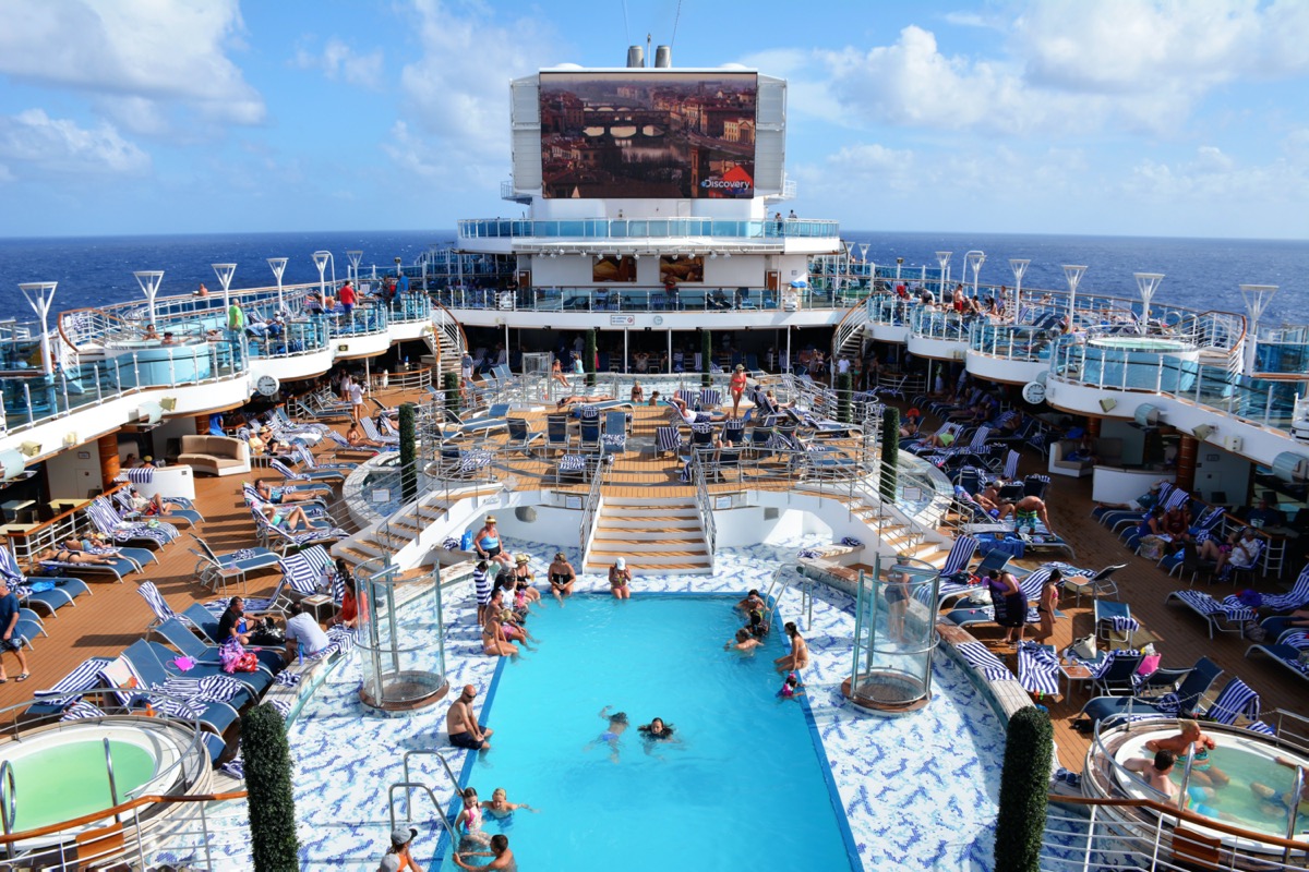 An overview of the pool and deck area of a crowded cruise ship