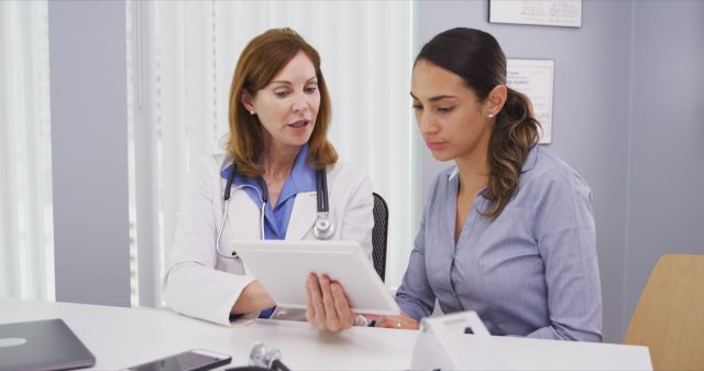 patient consulting with doctor on tablet