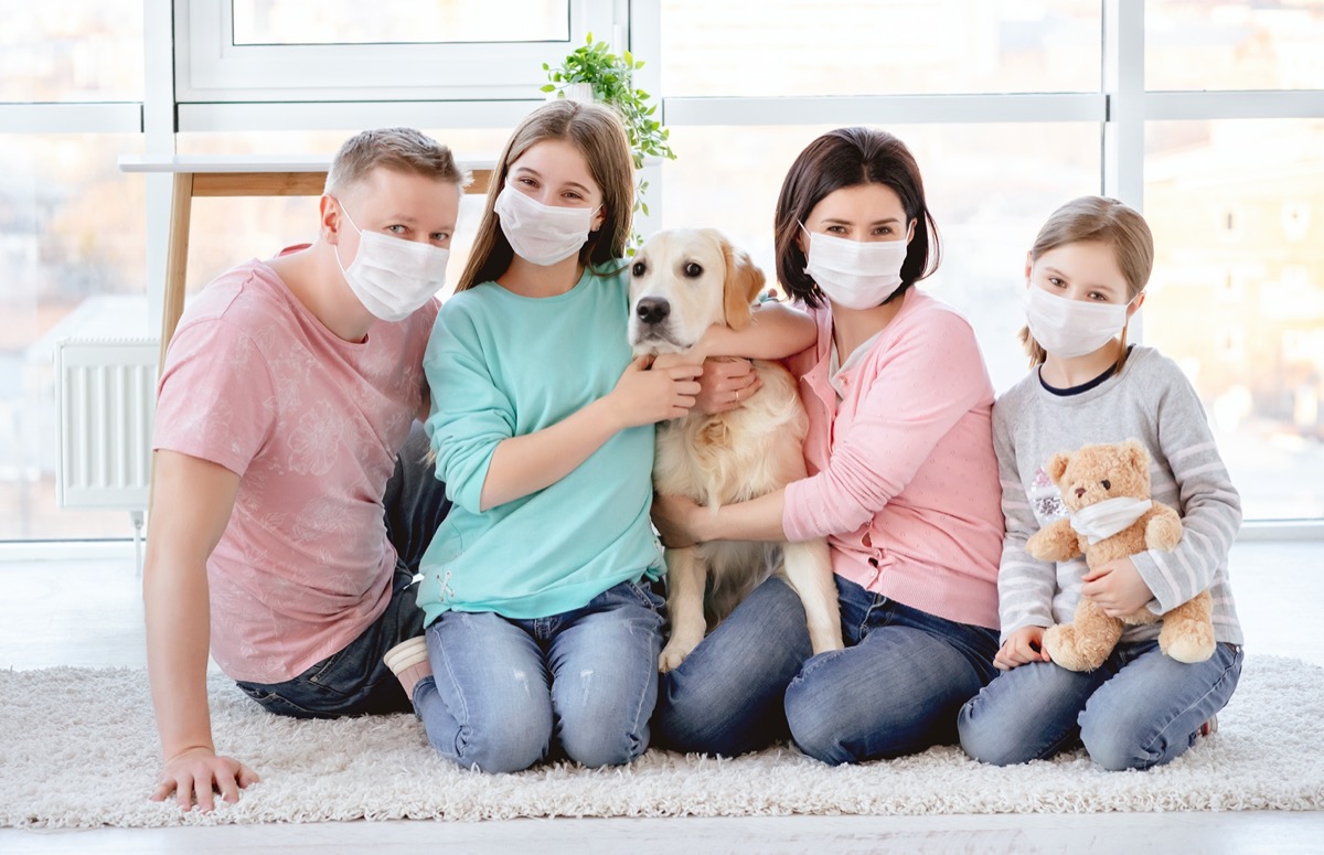 Beautiful family in medical masks against coronavirus at home