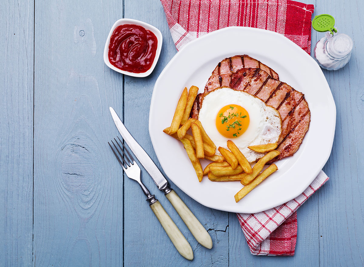grilled ham and fried egg on plate with french fries