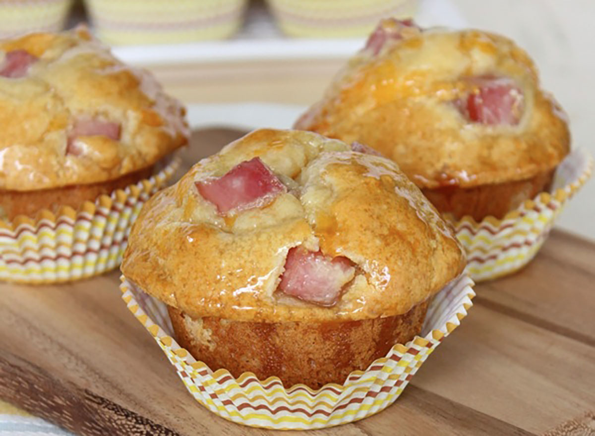 ham and cheddar biscuits in muffin tin liners on wood board