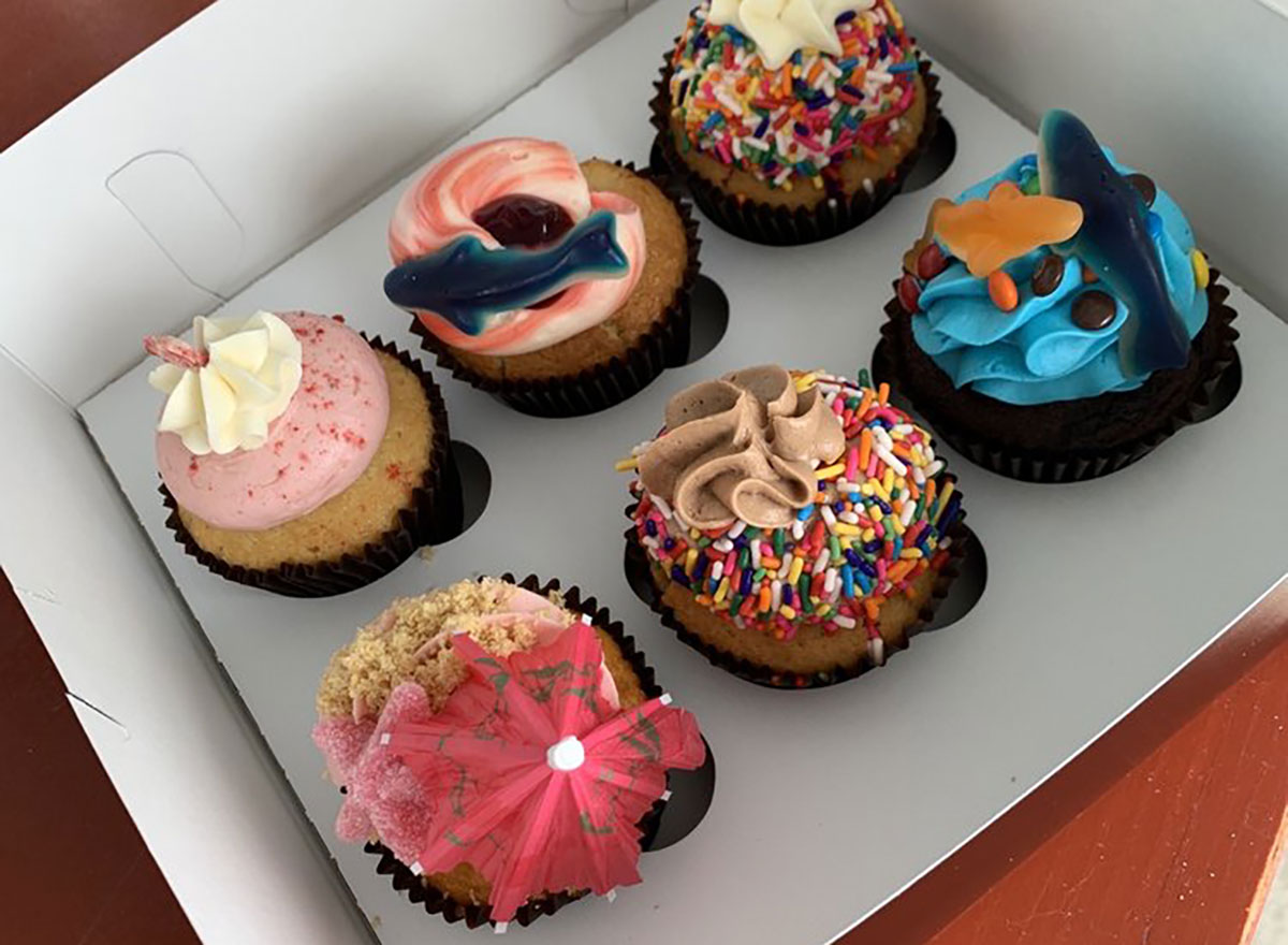 six decorated cupcakes in a box