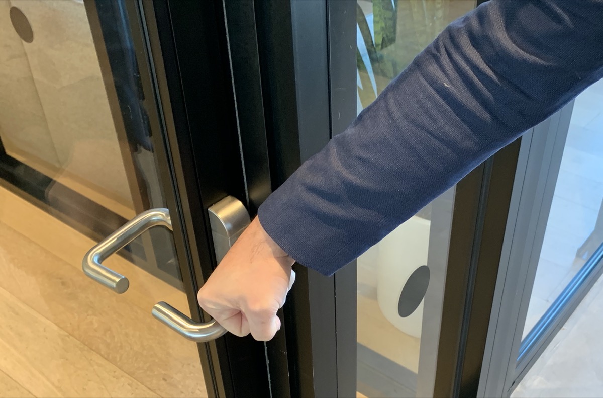 Man using his knuckle to open doors.