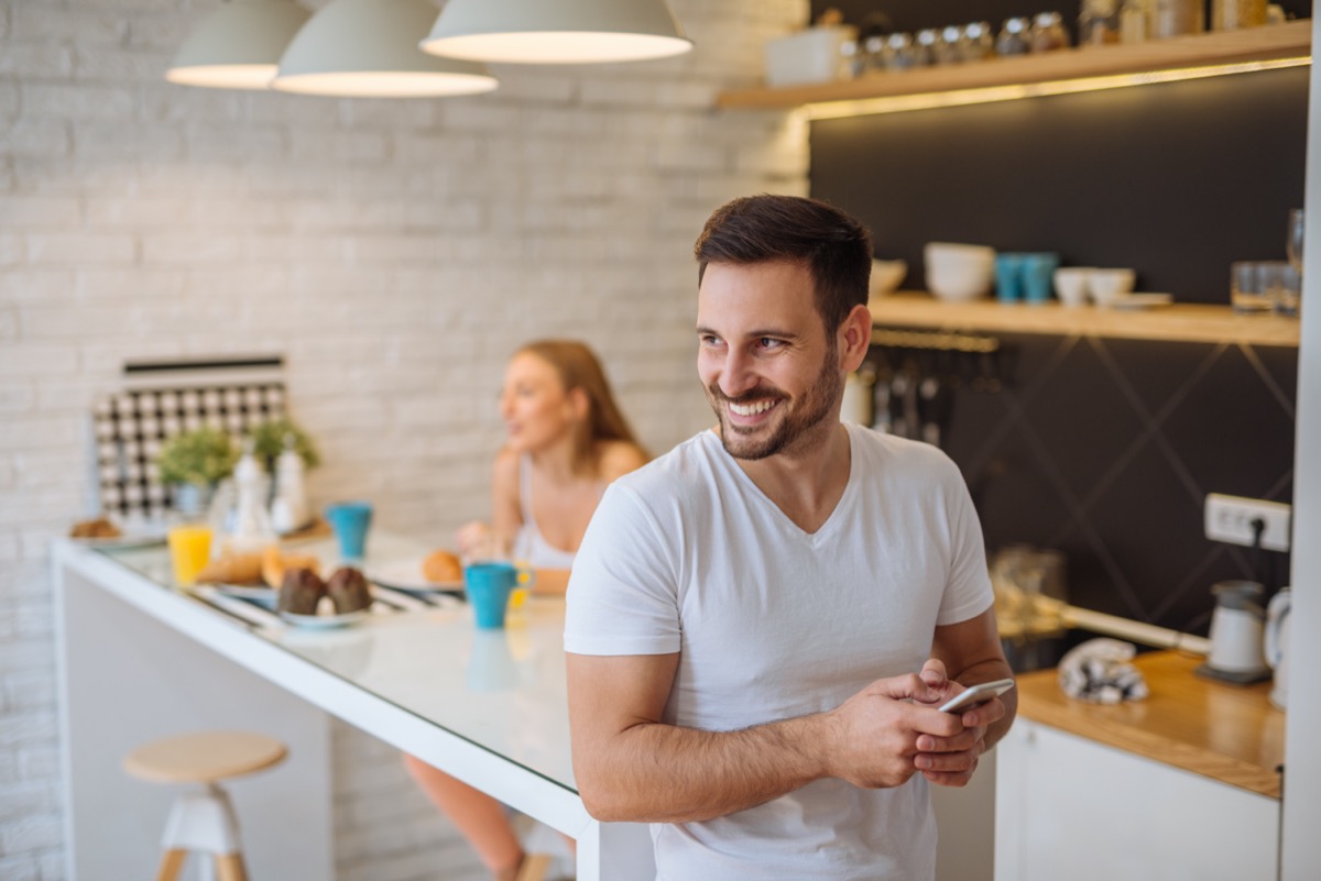 Handsome happy man holding a mobile phone.