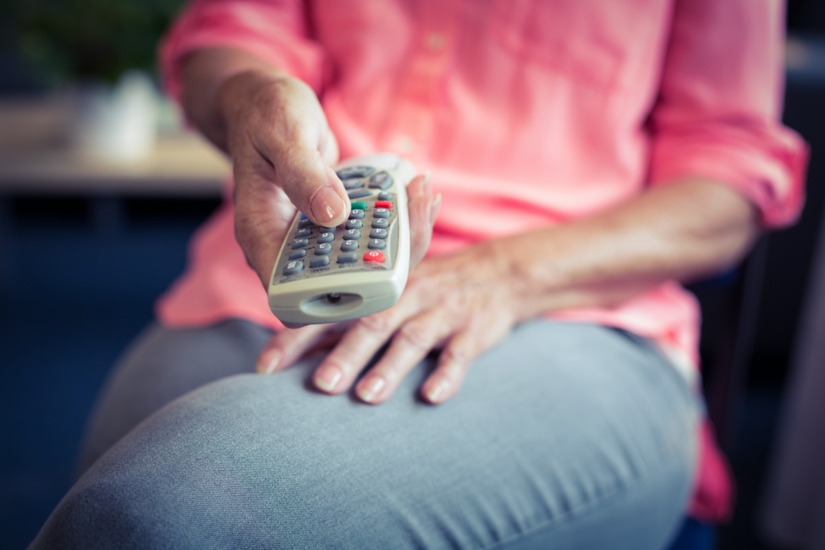 woman holding tv remote