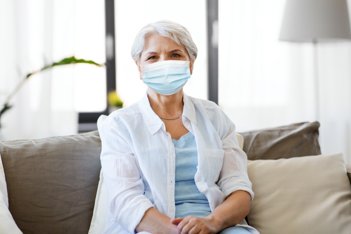 senior woman wearing protective medical mask for protection from virus at home