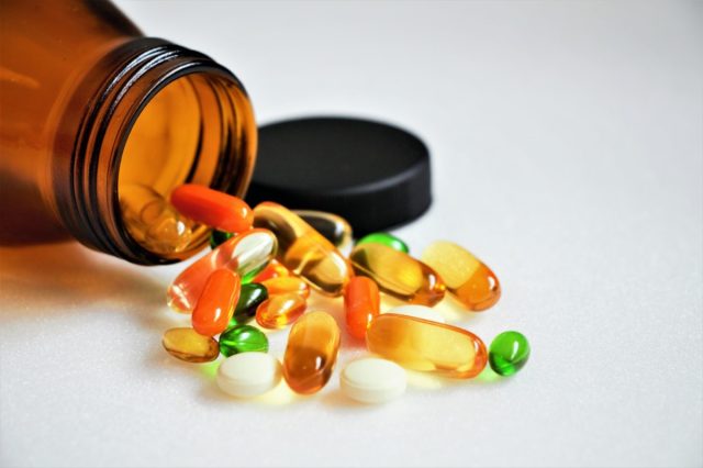 vitamins and supplements on white background with a brown bottle.