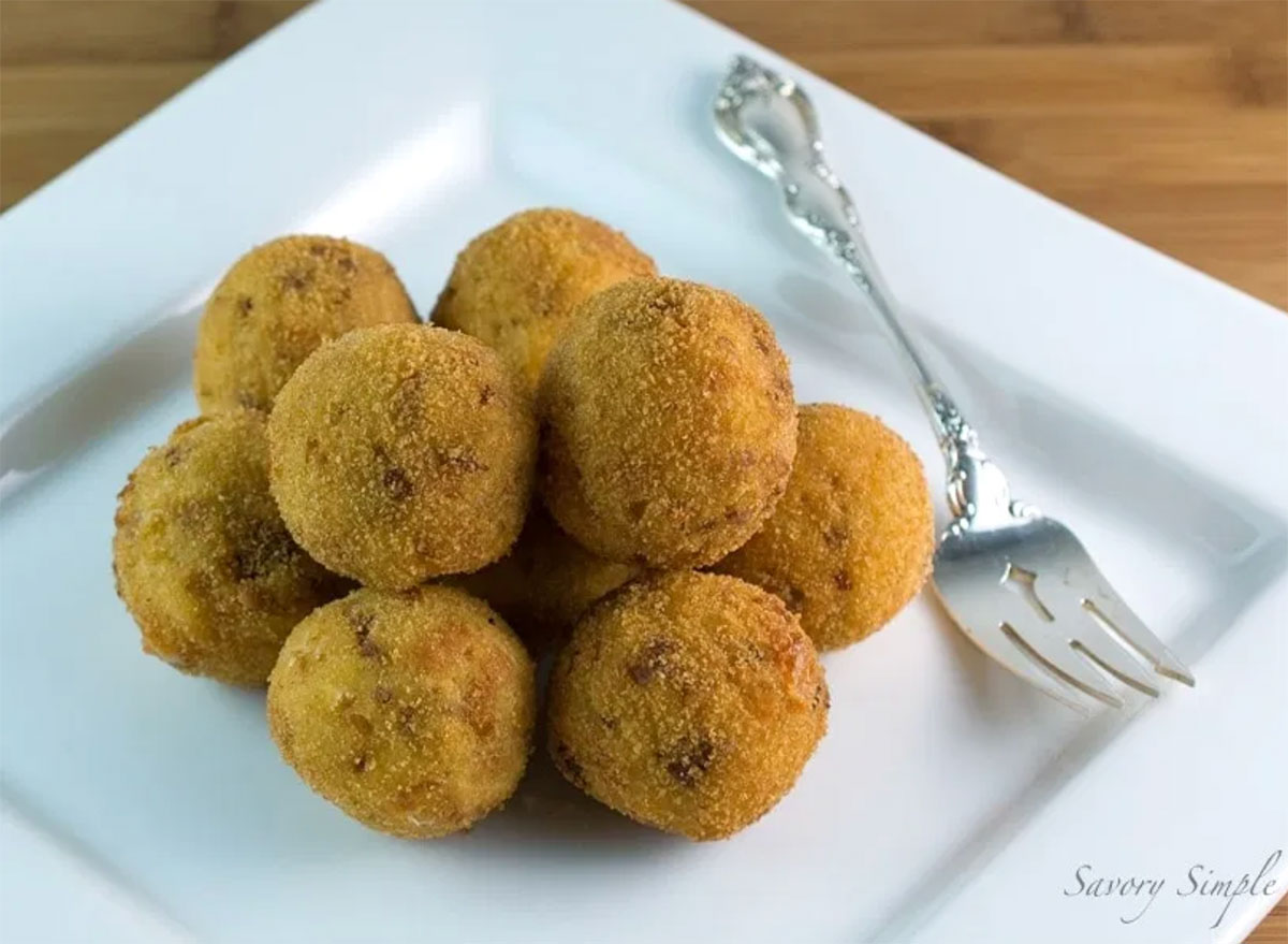 fried potato croquettes on white serving dish with fork
