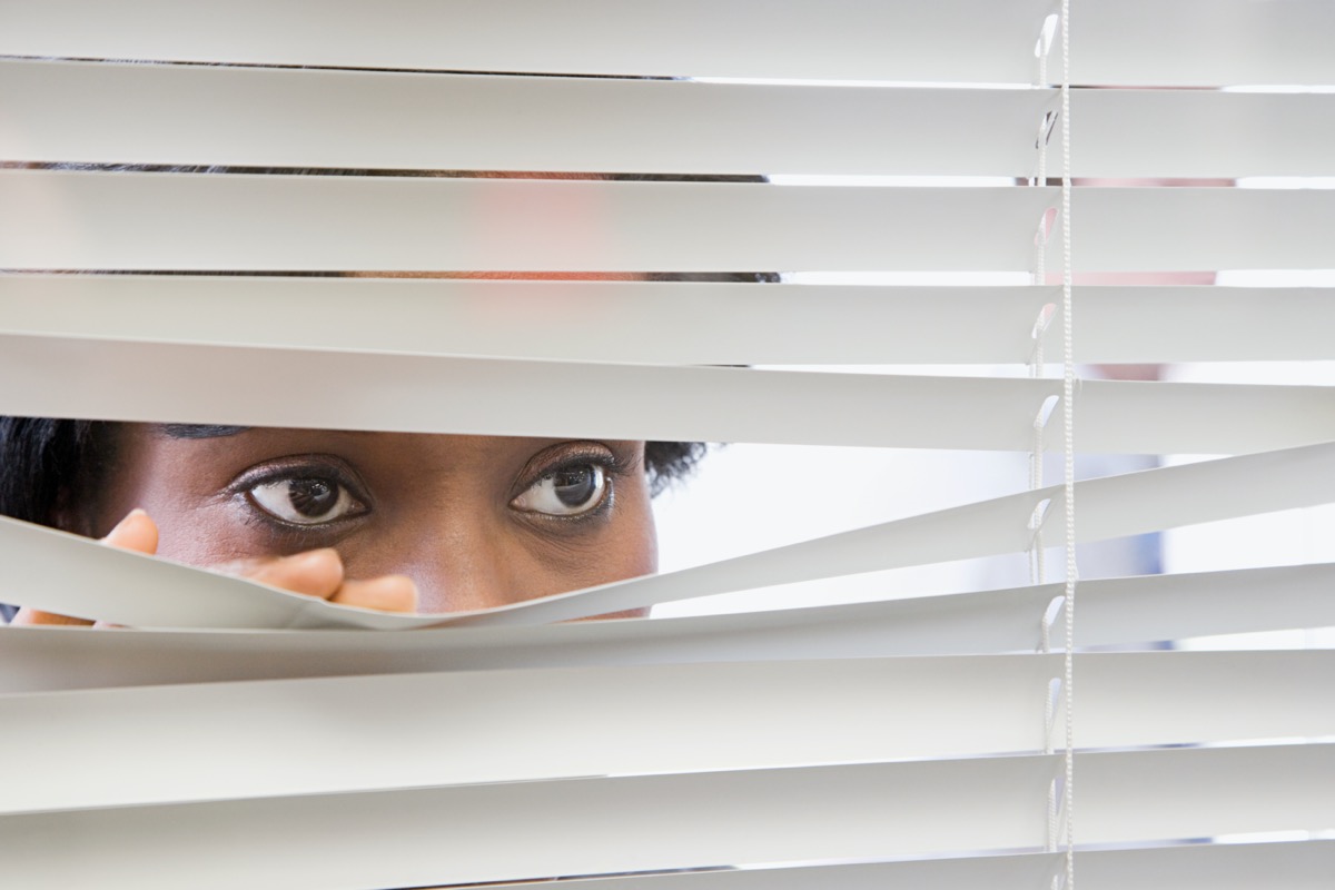 Sad woman blinds window quarantine isolation