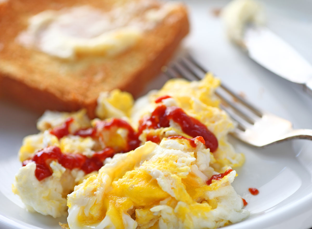 Scrambled eggs hot sauce buttered toast breakfast