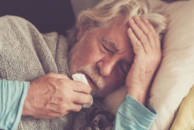 senior man with winter seasonal illness fever cold problems