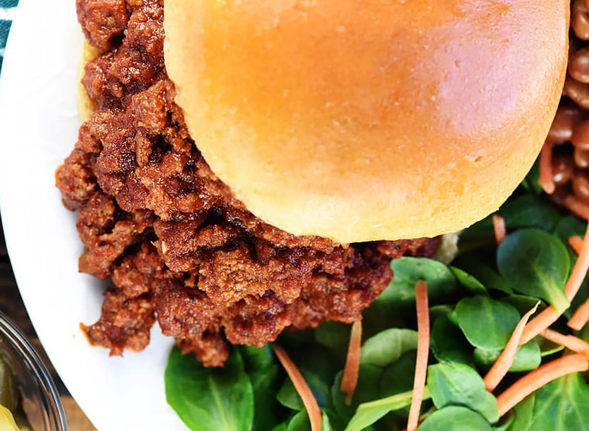 sloppy joe sandwich with salad on plate