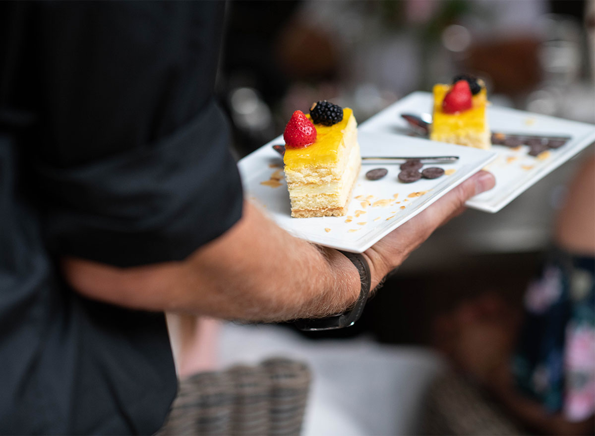 waiter carrying two cake slices