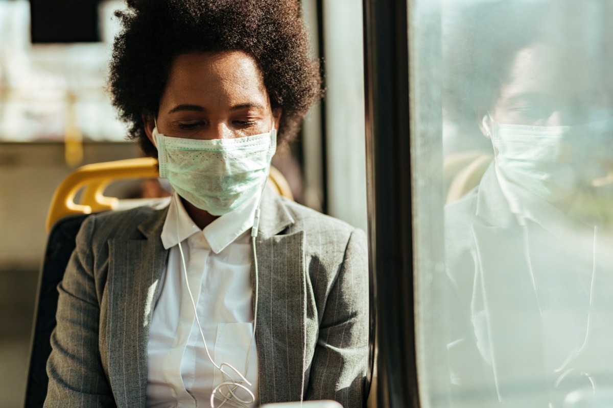 woman with protective mask on her face commuting by bus during virus epidemic.