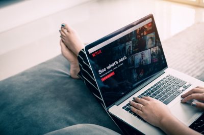 Woman using computer laptop and watching Netflix website