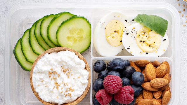 Breakfast bento box high protein with hard boiled eggs fruit nuts cottage cheese cucumber